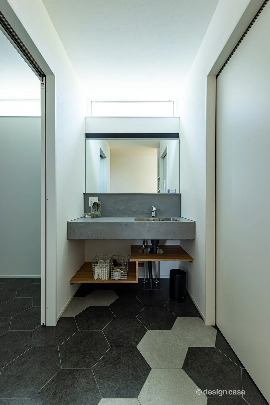 グレーの造作洗面カウンターとヘキサゴンタイルが印象的な、上質でシンプルな空間に。