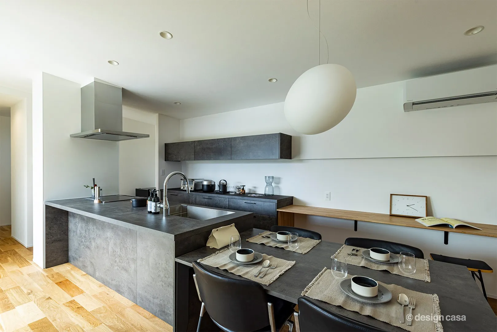 キッチン・カップボード・ダイニングテーブルが、べトングレーで統一された、家具のようなグラフテクトのキッチン。