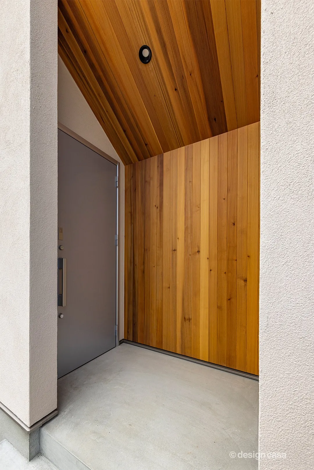 玄関ポーチは内側に内包するような構成。木質アクセントパネルが温かみをプラスします。